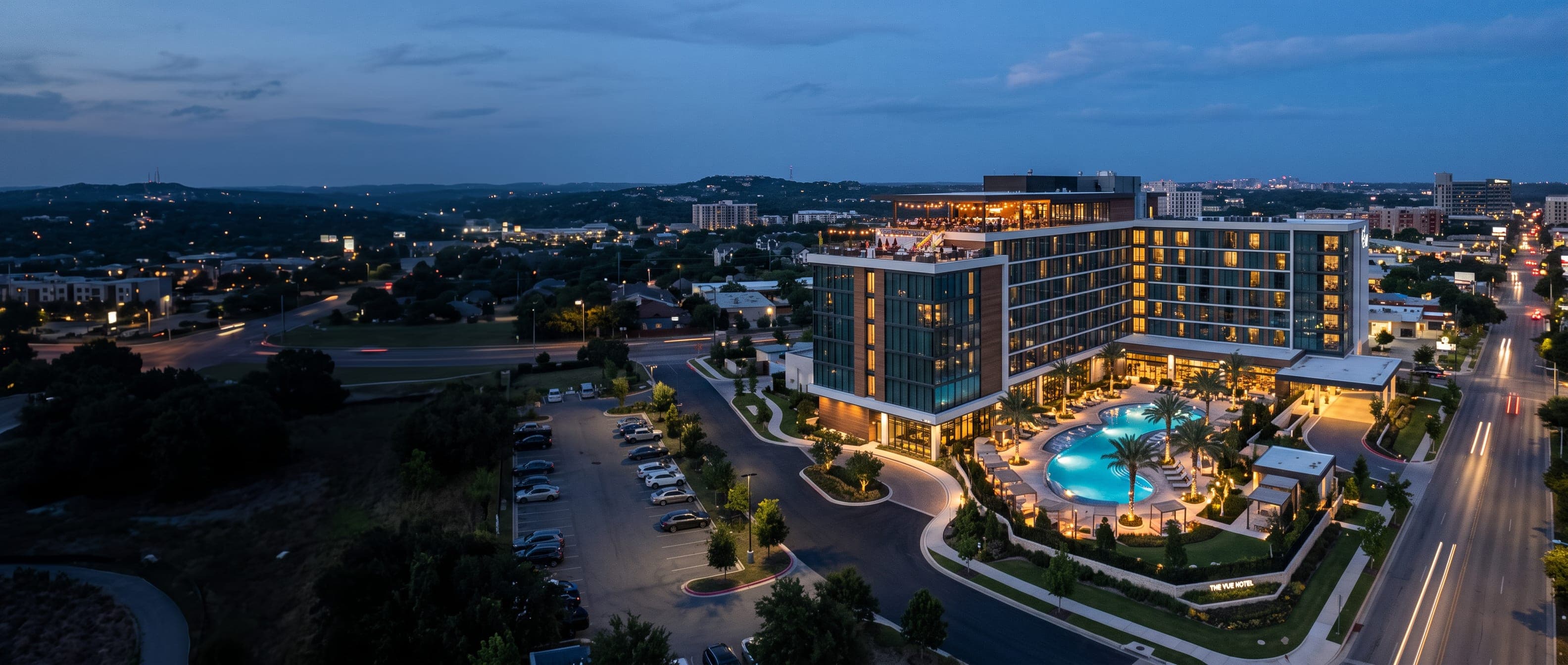 An aerial view of a waterfront apartment development at dusk.